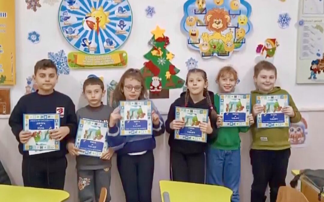 Ukrainian children lined up and holding the children’s book Toys at Night